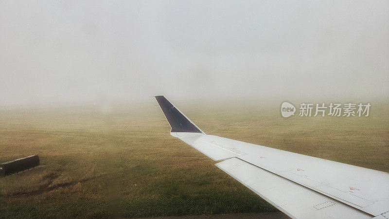 机场天气恶劣，能见度低，地面潮湿，飞机机翼