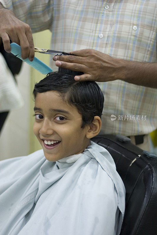 年轻开朗的印度男孩理发沙龙垂直