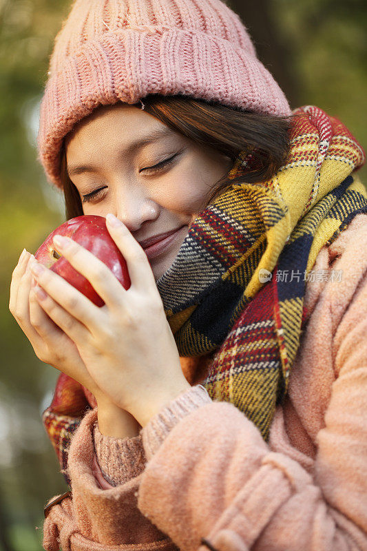 快乐的年轻女子正在吃苹果