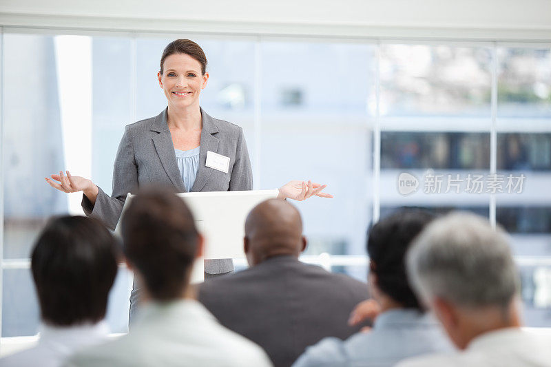 严肃的女商人用双手示意，而她的同事