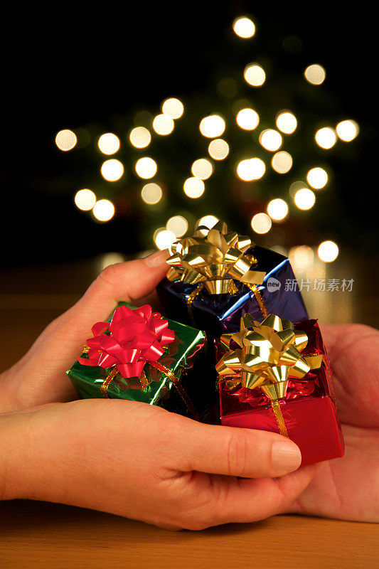 在模糊的灯光下，垂直地赠送和接收圣诞礼物