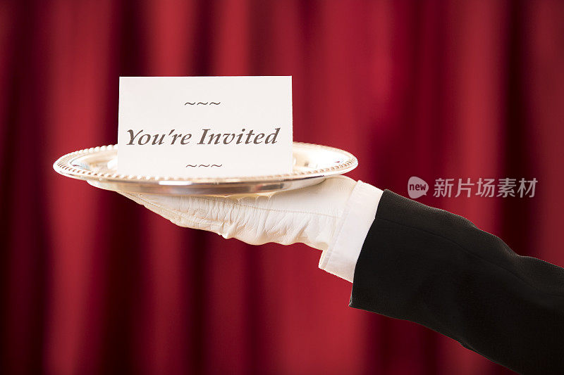 巴特勒拿着放在银盘上的“你被邀请了”卡片。红色的窗帘。