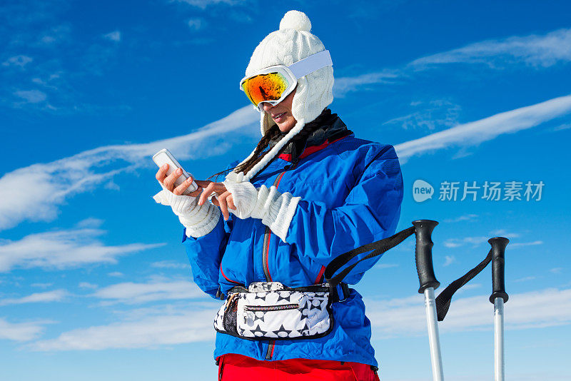 滑雪道上的女人拿着手机