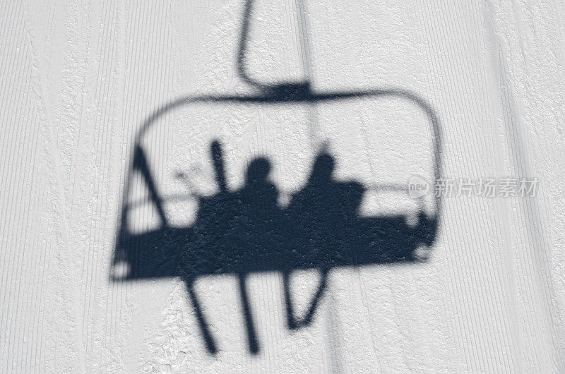 乘坐滑雪缆车的人的影子