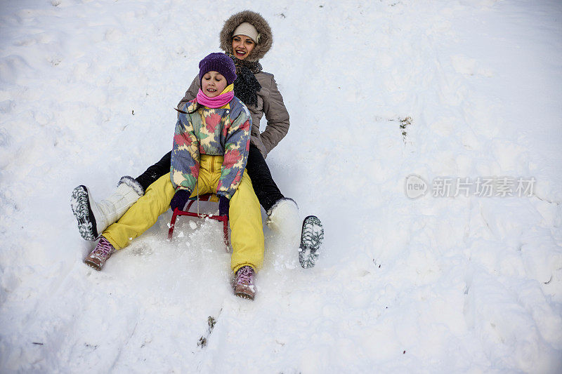 母亲和女儿喜欢坐雪橇