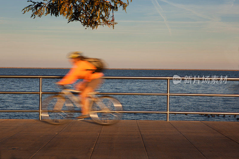 在威斯康辛州密尔沃基的密歇根湖上，一个骑自行车的人变成了一个模糊的人