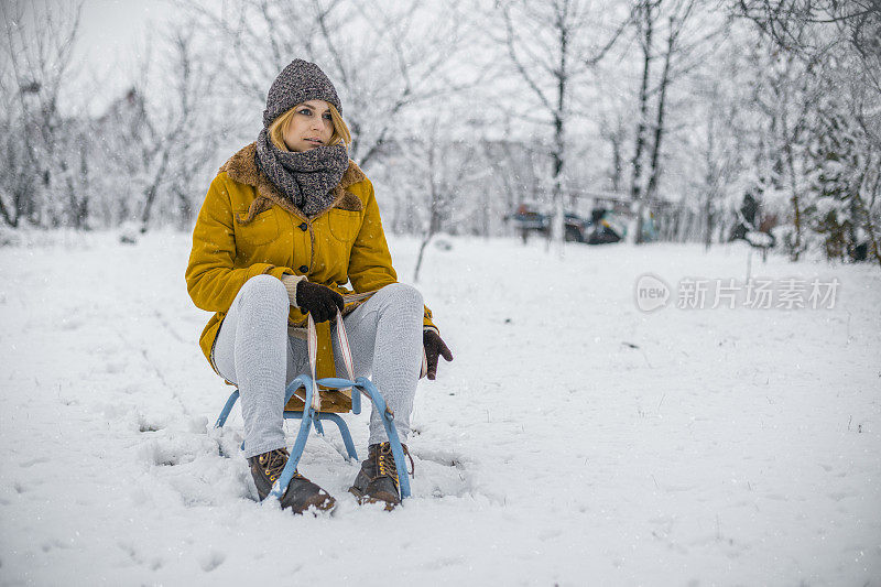 年轻女子在滑雪胜地拉雪橇