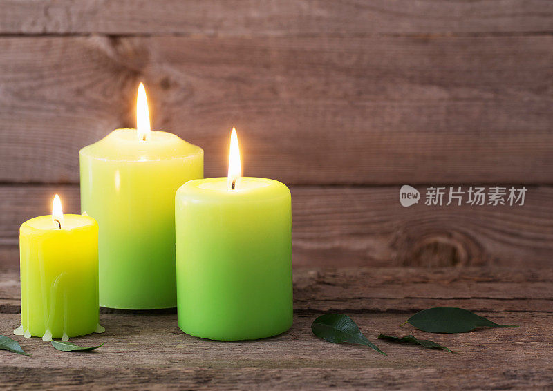 深色木质背景上的绿色蜡烛