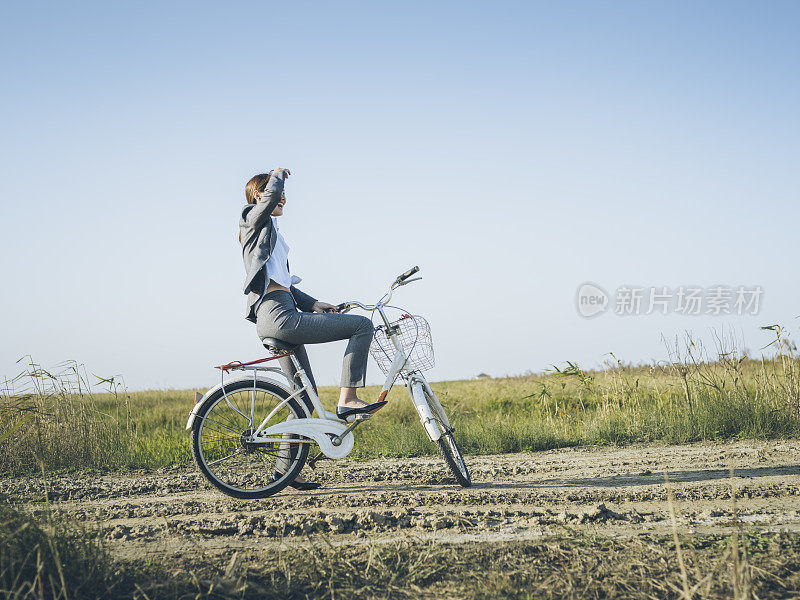 一个年轻的女商人坐在乡下的bicyale上的肖像