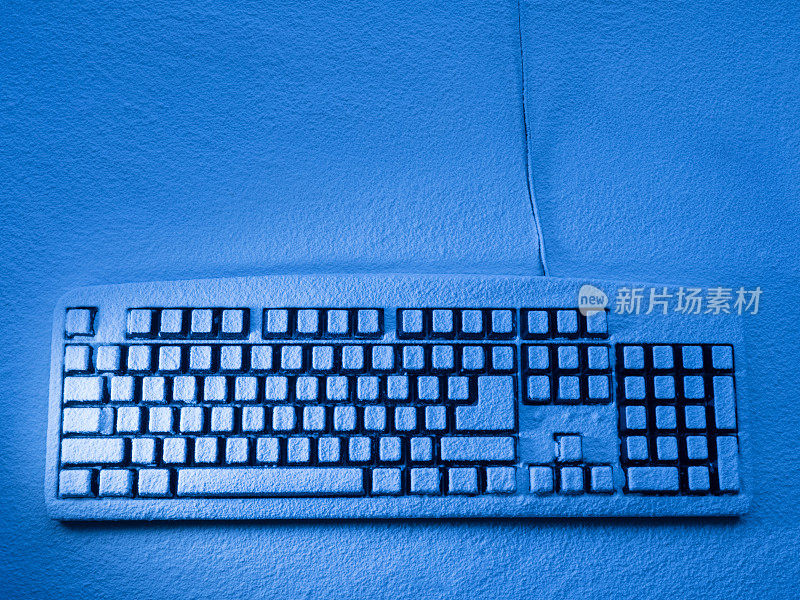 电脑键盘站在覆盖着雪的平面上，用蓝色的灯光照亮，有拷贝空间