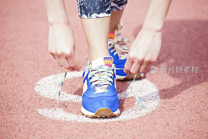 年轻女子跑步系鞋带