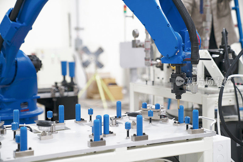 工业自动化机器人手臂在工厂里握住汽车玻璃