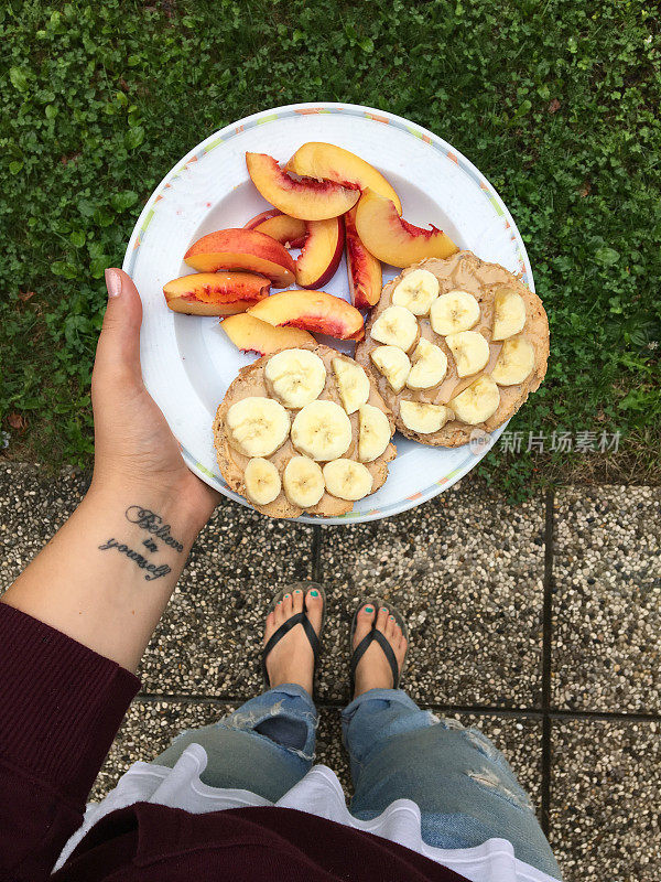 手里拿着一盘新鲜素食早餐的女人