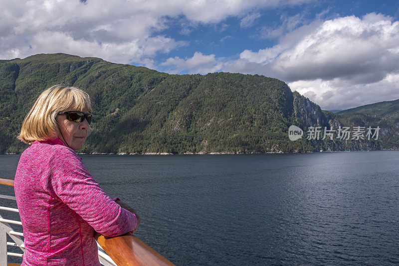 从游轮上欣赏挪威海岸风景的女人