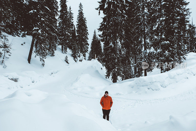 红色的人走在山上森林飘落的雪