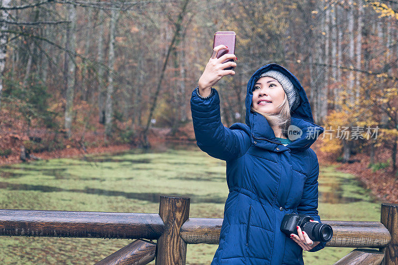 一名女子在公园里用手机自拍