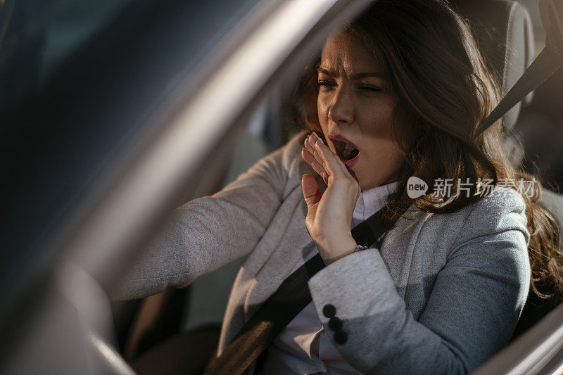 女商人开车累了昏昏欲睡的女商人开着她的车