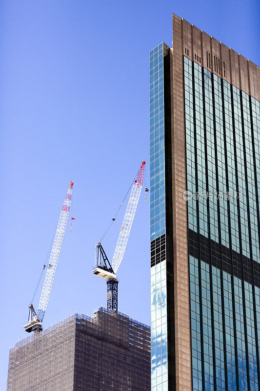 用塔吊、蓝天背景、复制空间建造摩天大楼