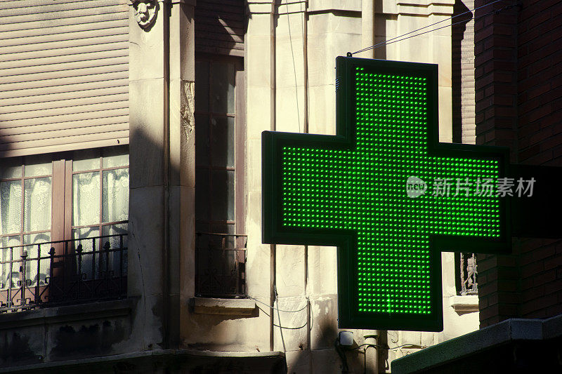 药店的标志在大街上，老城区，绿十字。