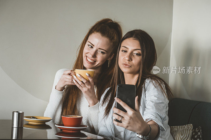 年轻的女性朋友们正坐在Café上拍摄美丽的瞬间