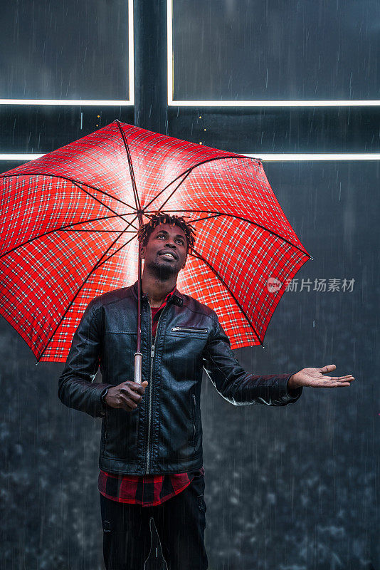 男人撑着红伞下着雨