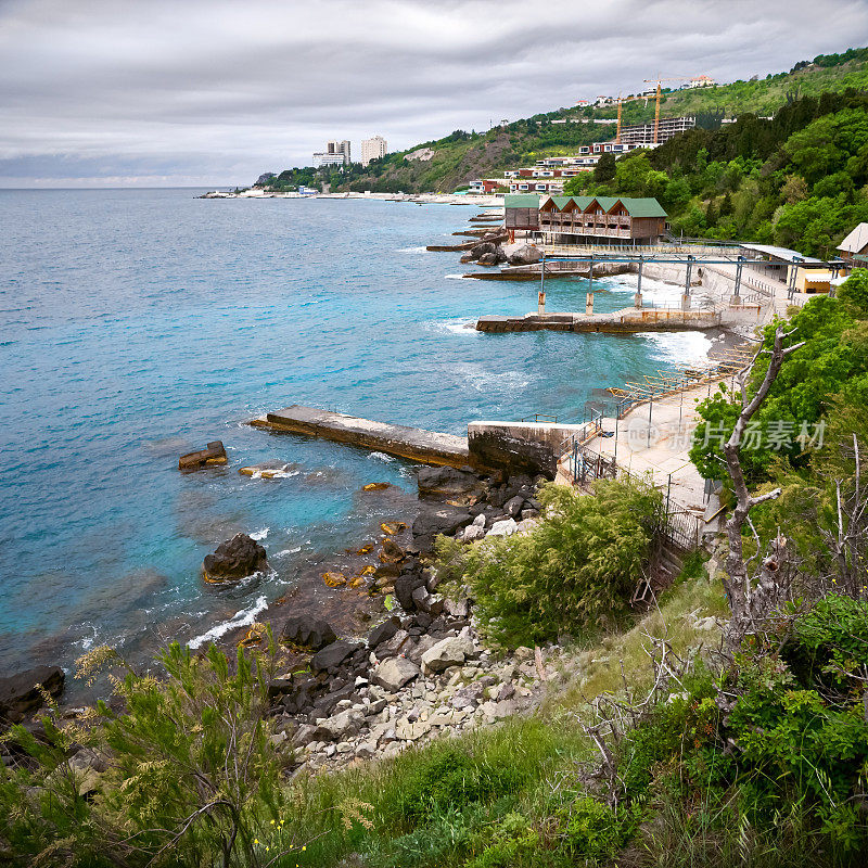 黑海海岸，郁郁葱葱的树叶，深蓝色的水，阴沉的天空