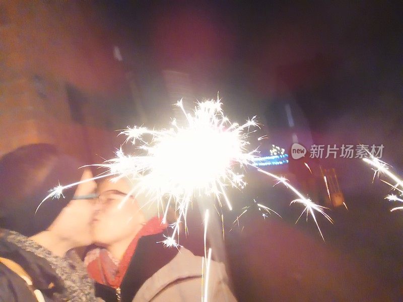 在新年前夕，一对情侣被神奇的烛光包围着亲吻
