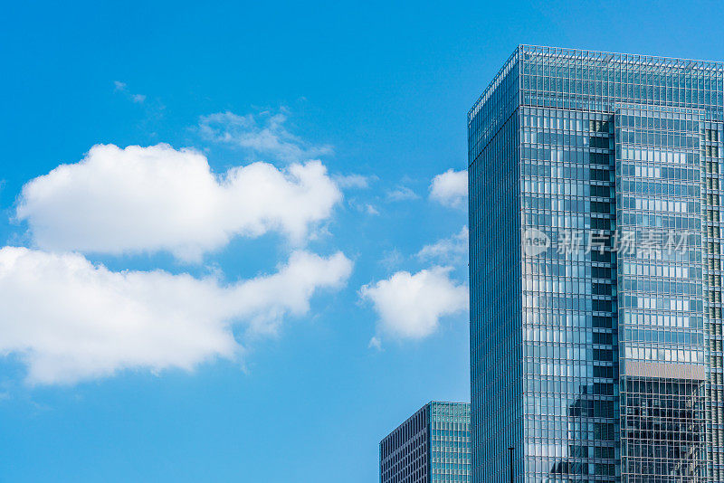 在日本东京，仰望蓝天白云的现代城市全景