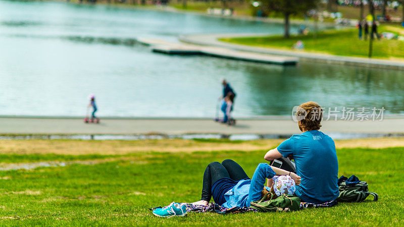 一对年轻夫妇在蒙特利尔皇家山的卡斯特湖畔享受午后时光