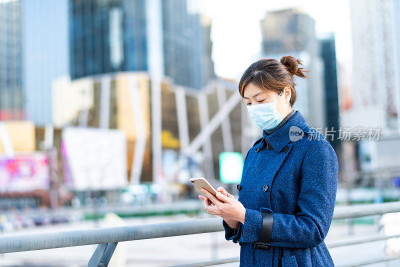 在城市街道上戴着口罩的亚洲妇女