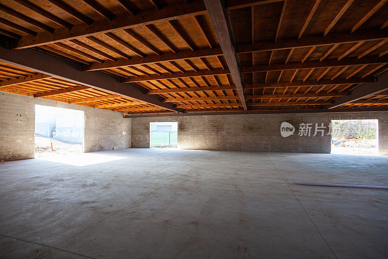一幢办公楼的空装修工地仓库，混凝土地板和木天花板