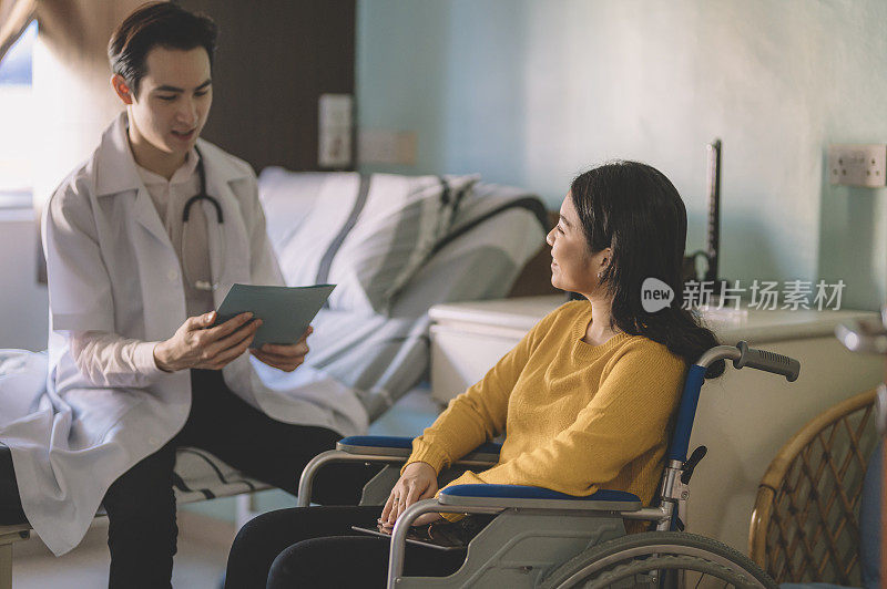 病房里，一个坐在轮椅上的亚裔中国少女与她的医生交谈
