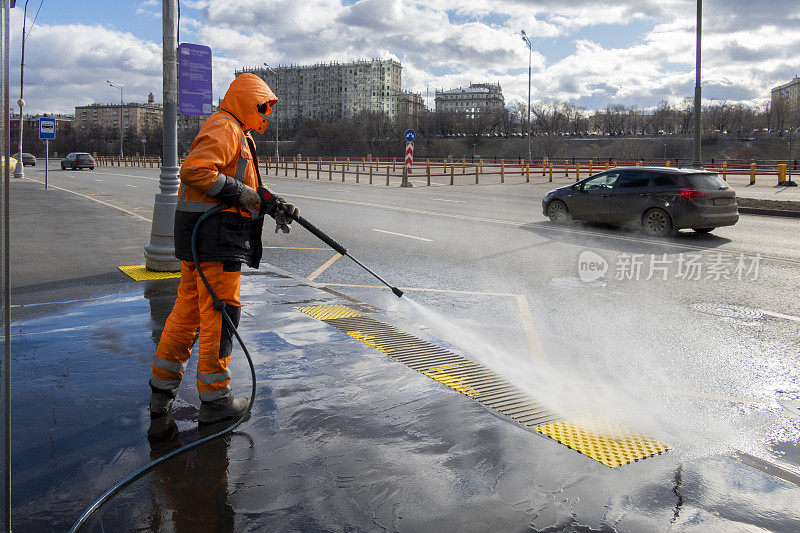 道路工人用高压动力清洗机清洁城市街道，清洁肮脏的公共交通站点，莫斯科，俄罗斯