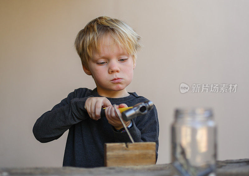 一个和木工工具一起工作的小男孩