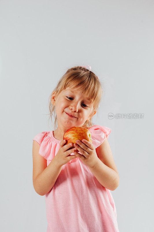 一个漂亮的小女孩拿着苹果