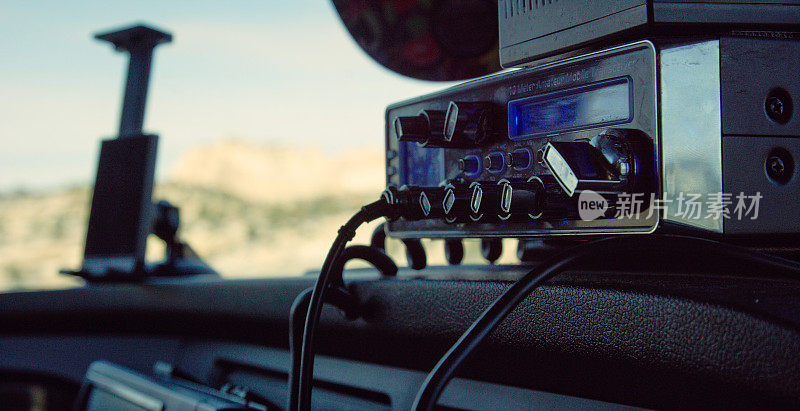 在一个阳光明媚的日子里，一台CB收音机停在一辆半卡车的仪表板上