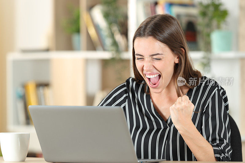 兴奋的女人在笔记本电脑上查看好消息