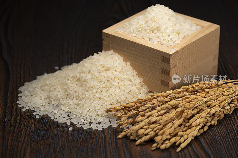 方形木杯里的大米和稻穗
