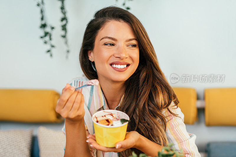 快乐的年轻女子享受在滚动的冰淇淋