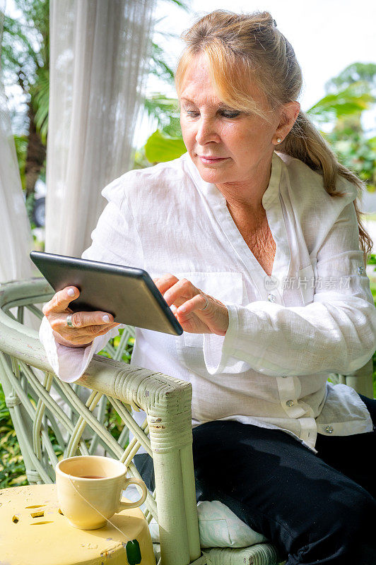 一位60多岁的妇女在户外使用平板电脑