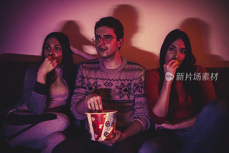 一群年轻人在家里看电影的时候吃零食