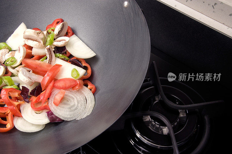 把切碎的蔬菜放在炉子上的煎锅里