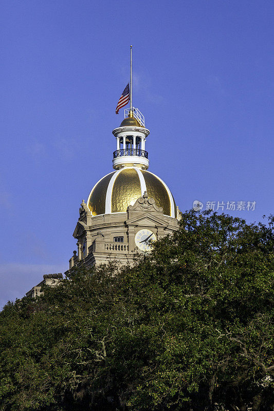 在庄严的南部橡树的环绕下，我们可以看到萨凡纳著名的市政厅的金色圆顶和钟面，美国国旗在这里降半旗