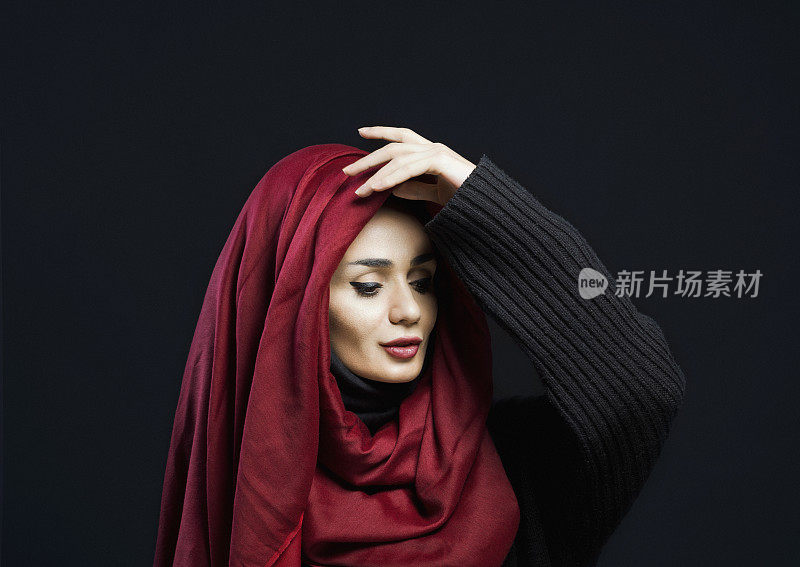 一个美丽的穆斯林妇女的肖像戴着头巾，近距离的工作室肖像，黑色的背景