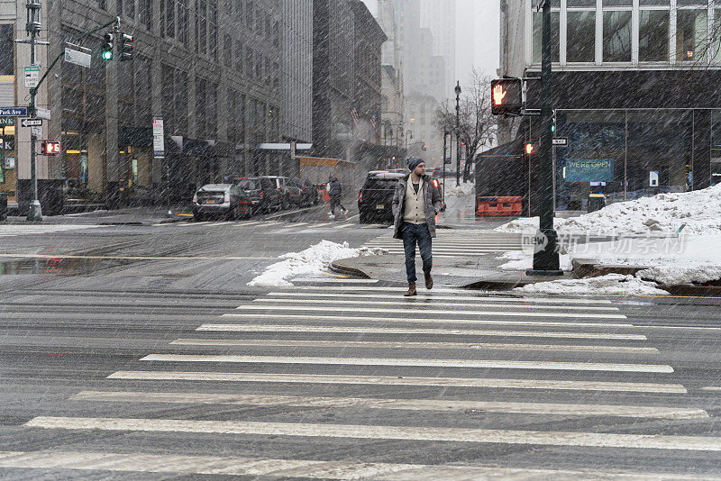 一名年轻游客，在一场大雪中穿过曼哈顿的街道