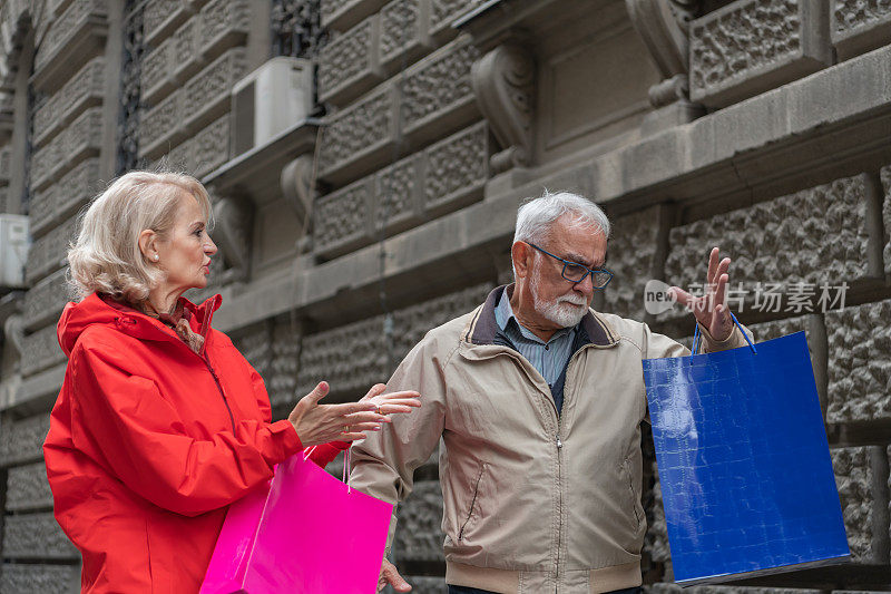 一对愤愤不平的退休老人在城市里散步并愤怒地辩论。
