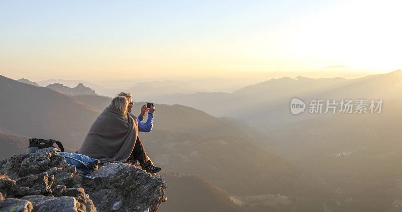 成熟的夫妇在日出时在山脊上放松