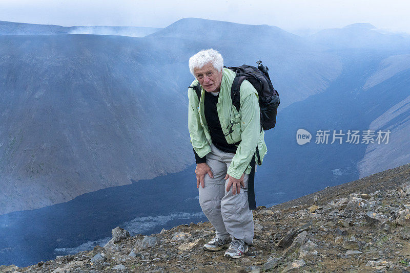 冰岛Fagradalsfjall火山上一名帕金森病患者，背景是冷却的熔岩外壳