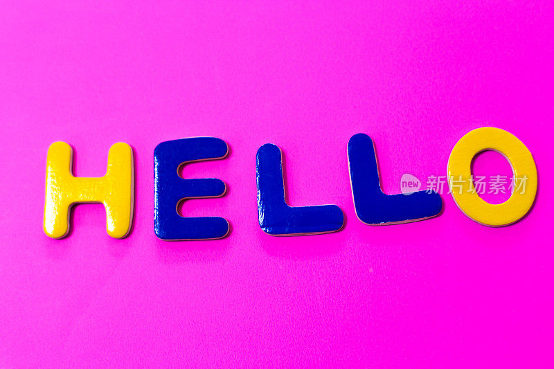 你好:单词写在玩具字母，鲜艳的粉红色背景