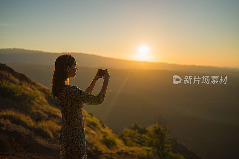 日出时，女徒步旅行者在山脊上休息